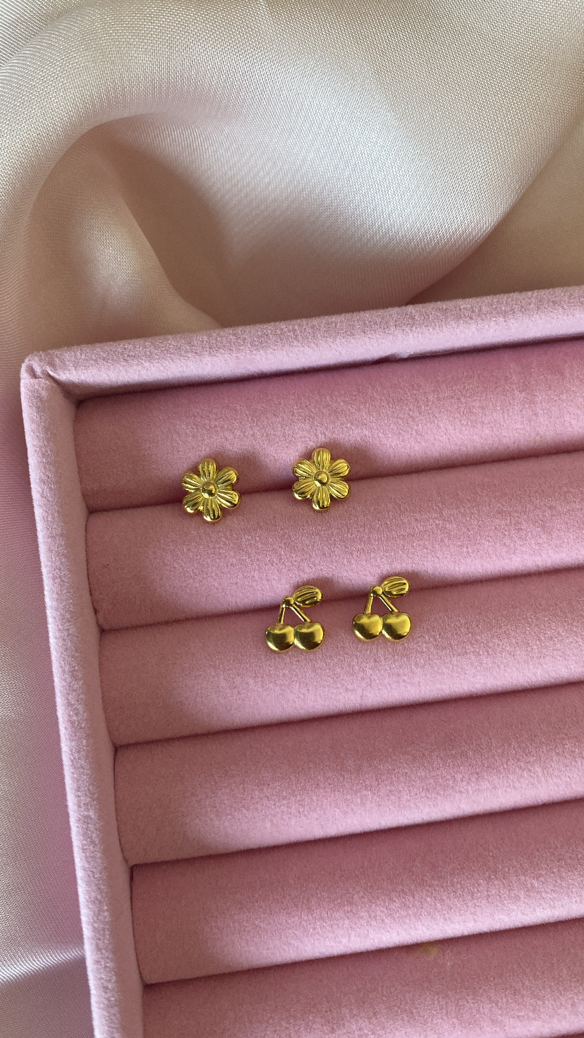 Dois pares de brincos dourados em caixa rosa com fundo de tecido cetim