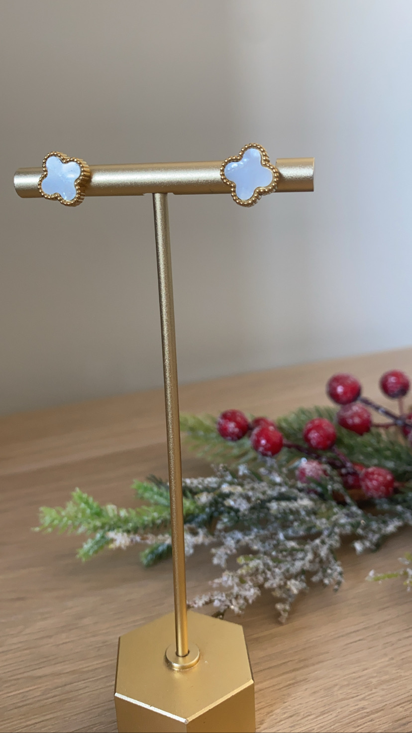 Brincos em forma de trevo branco com contorno dourado em suporte dourado