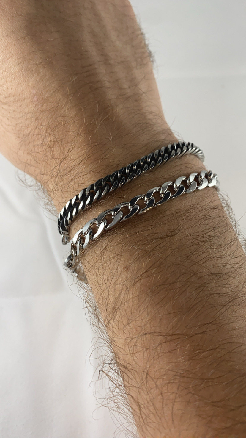 Duas pulseiras de corrente em pulso sobre fundo branco