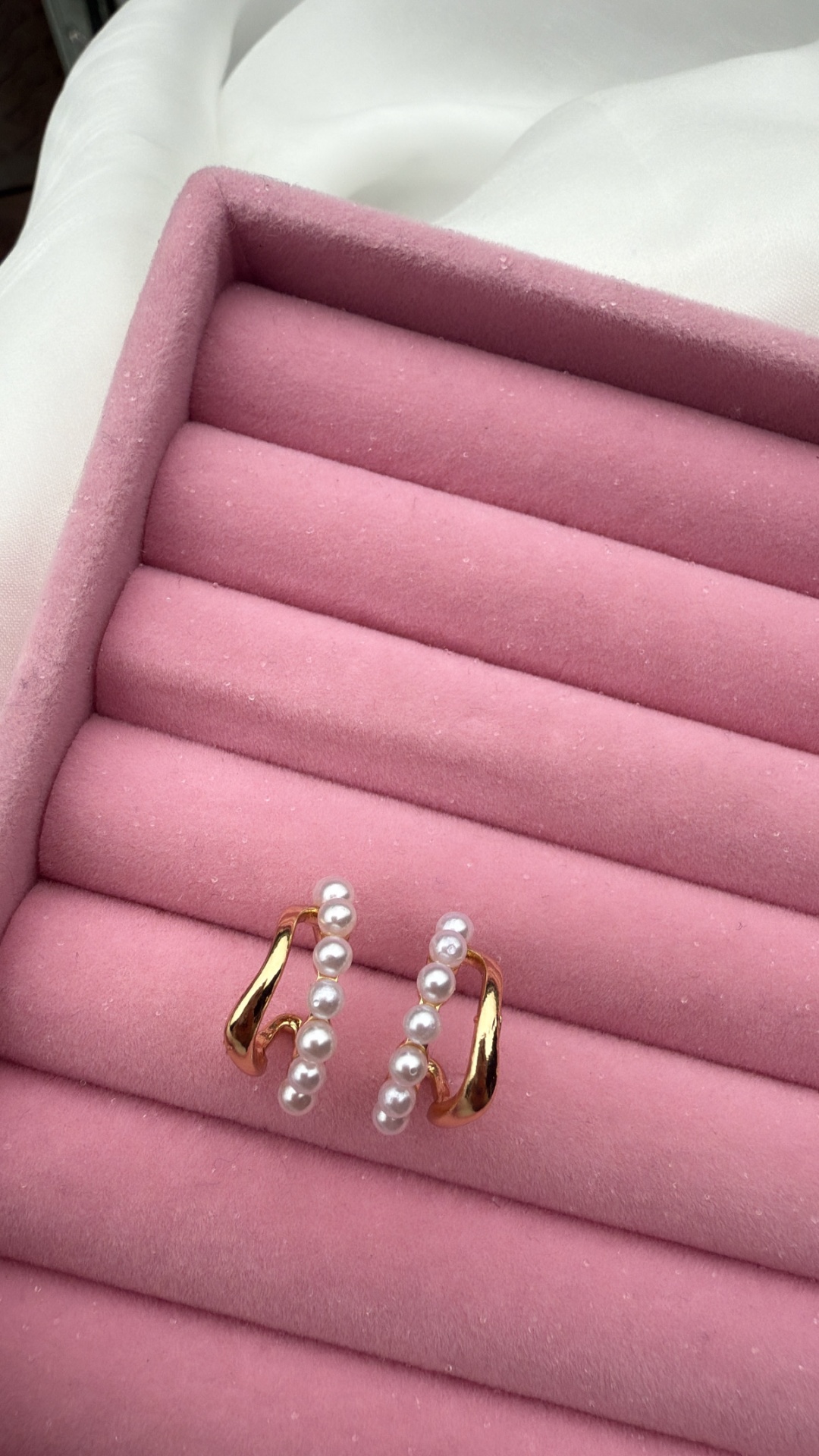 Par de brincos dourados com pérolas em caixa rosa de veludo