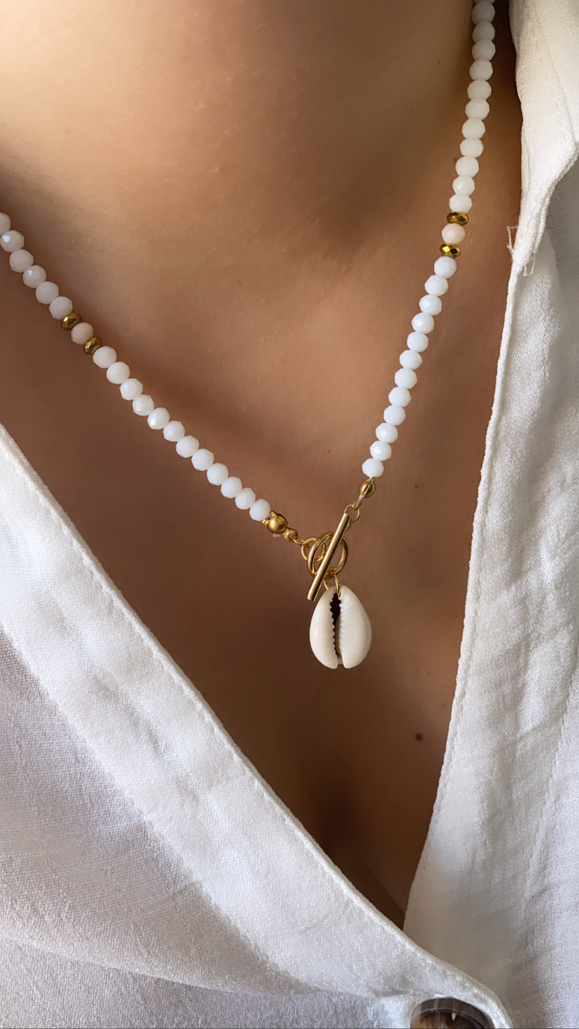 Colar de contas brancas e douradas com concha natural pendurada
