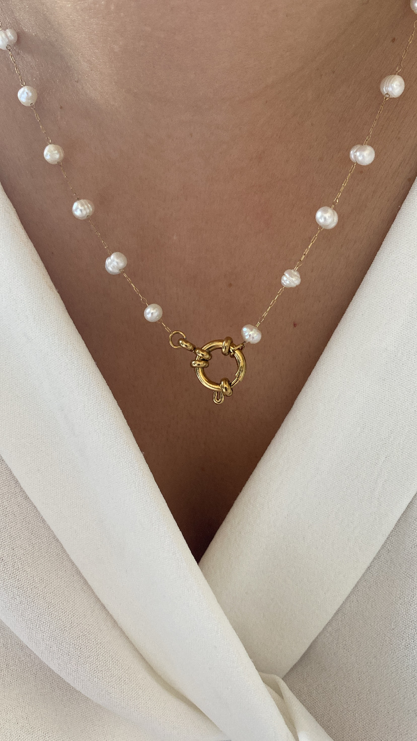 Colar com pérolas brancas e corrente dourada, usado com roupa branca