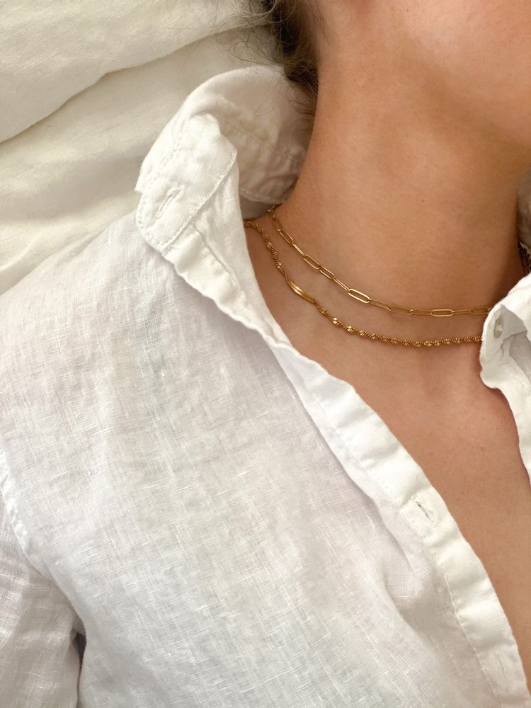 Colar dourado em dois fios e camisa branca de linho com gola aberta