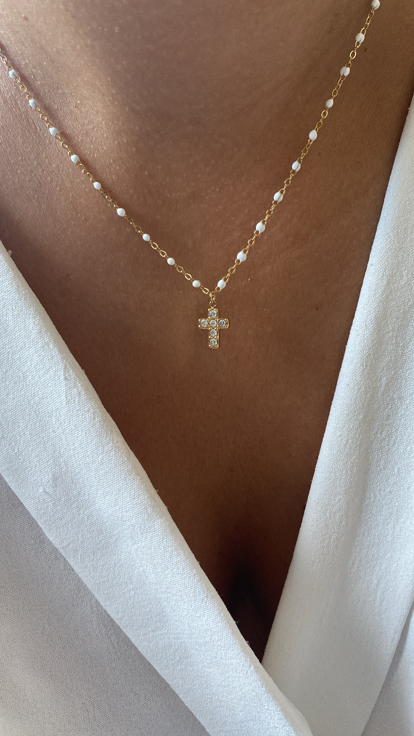 Colar dourado com pingente cruz e pérolas pequenas na corrente