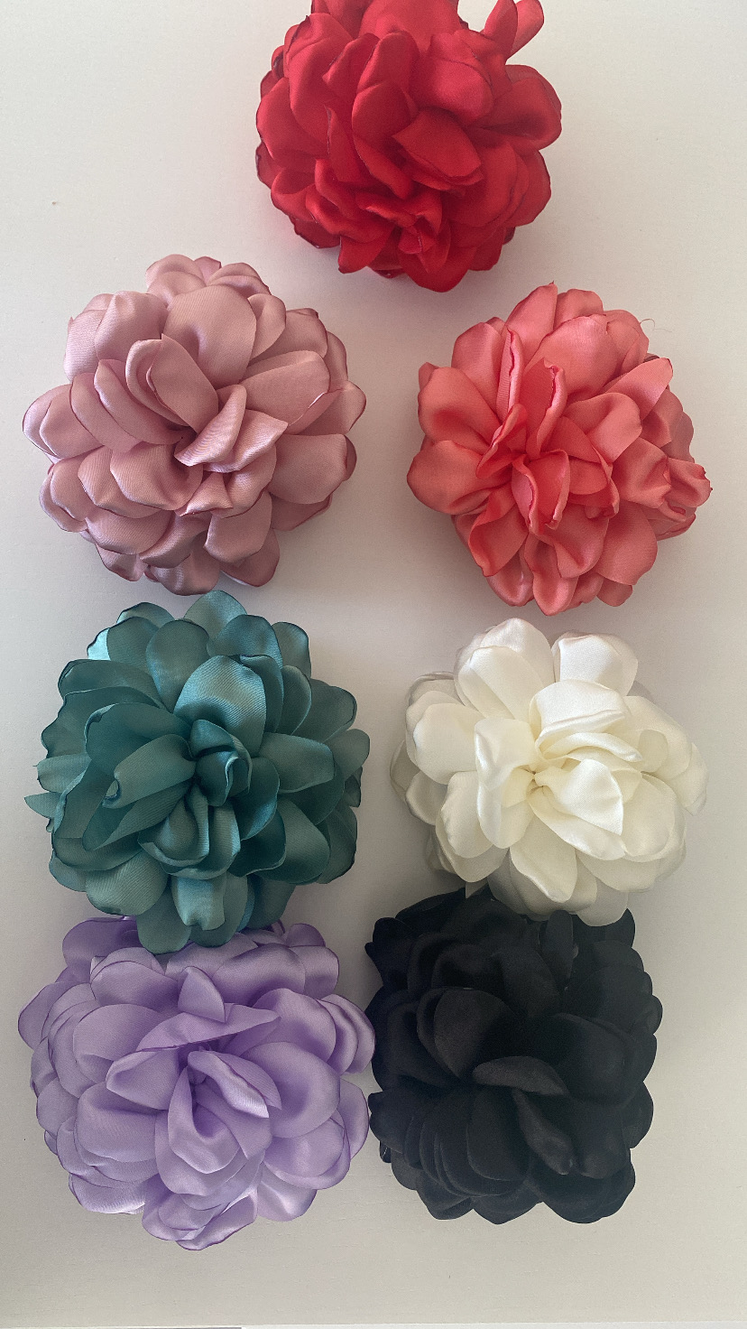 Flores artificiais de tecido coloridas em superfície branca