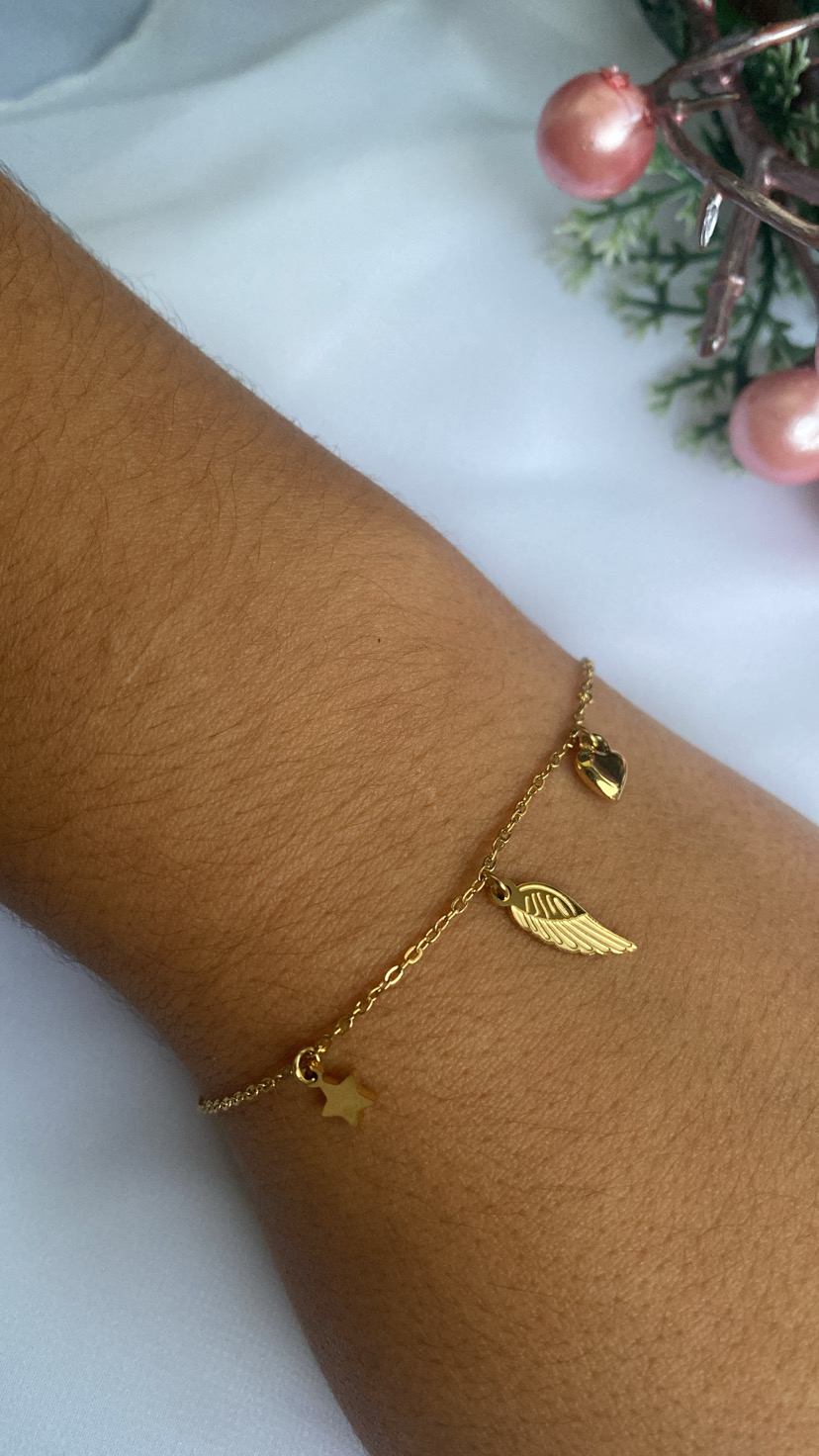 Pulseira dourada fina com pendentes em forma de estrela, asa e coração