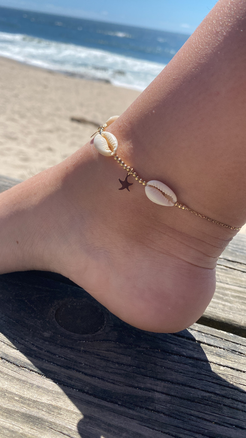 Tornozeleira com búzios e estrela na praia