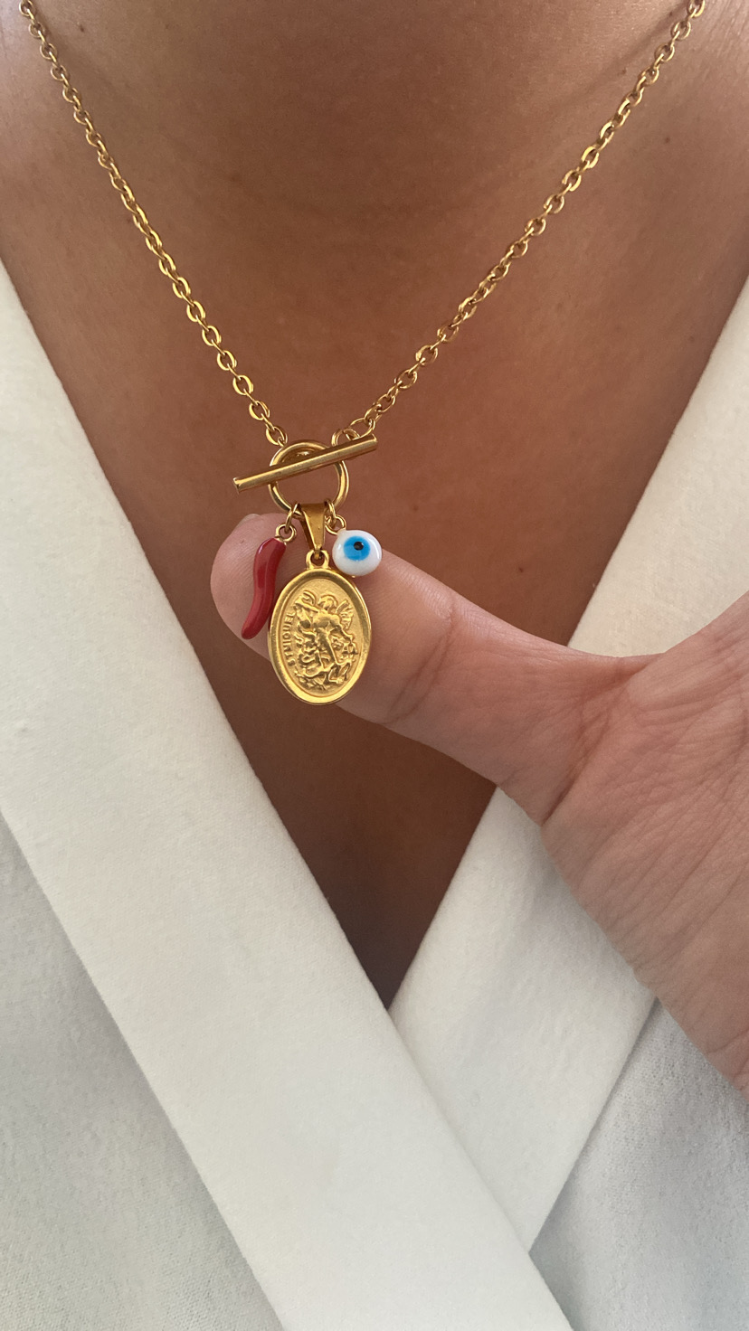 Colar dourado com pendentes de moeda, olho azul e chifre vermelho