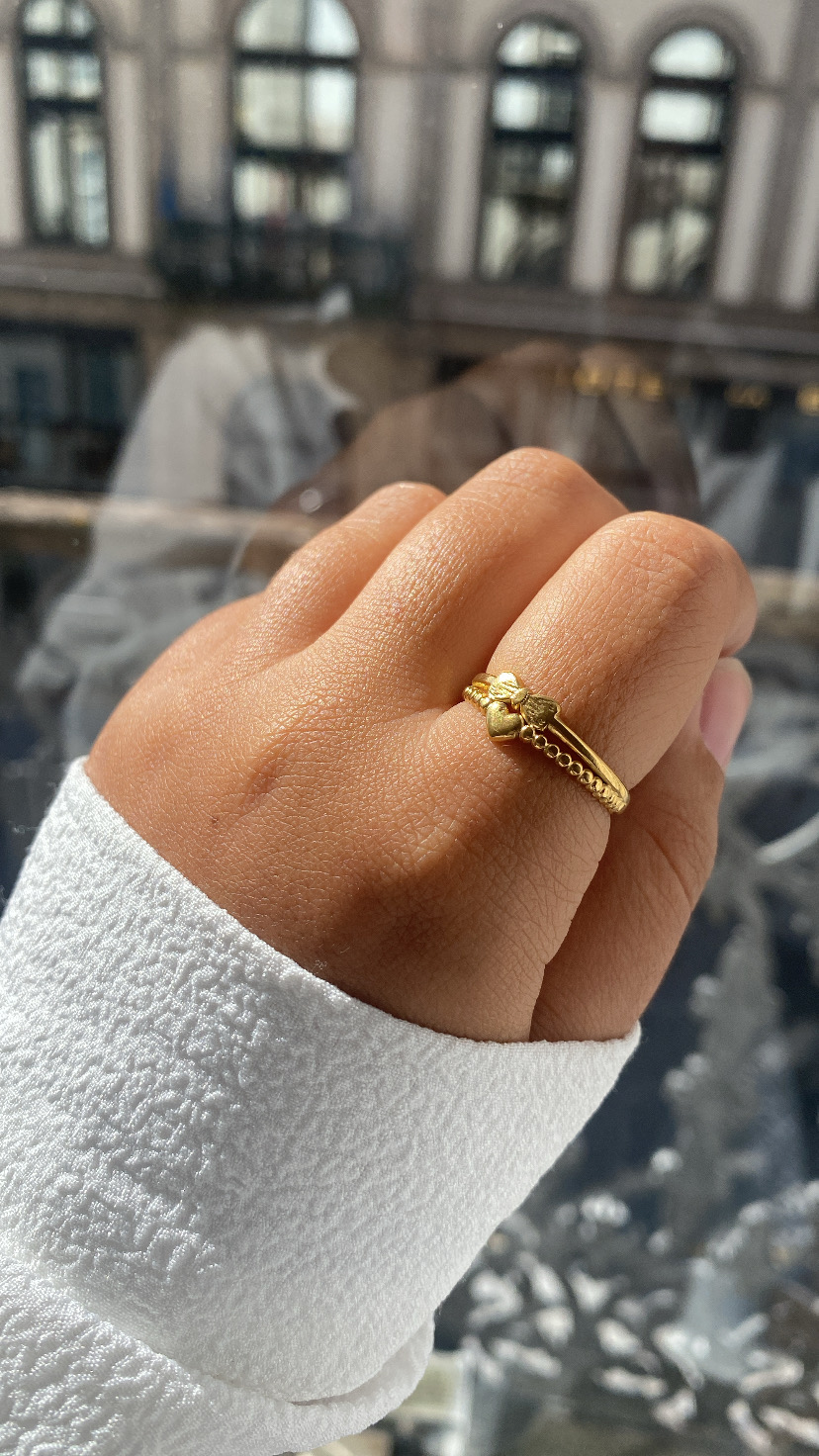 Mão com anel dourado estilo corrente com figura decorativa