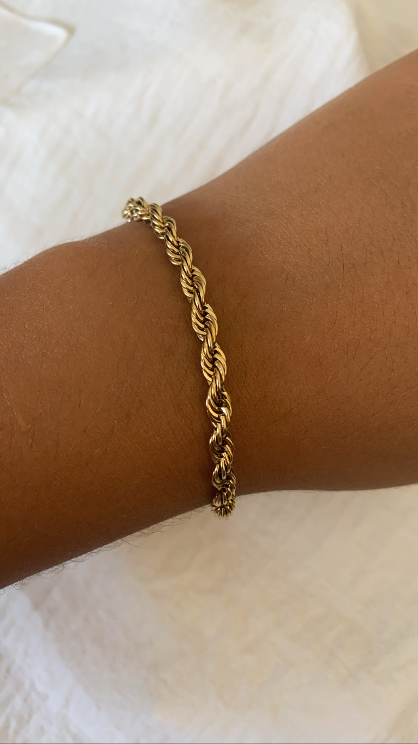 Pulseira dourada em espiral no pulso