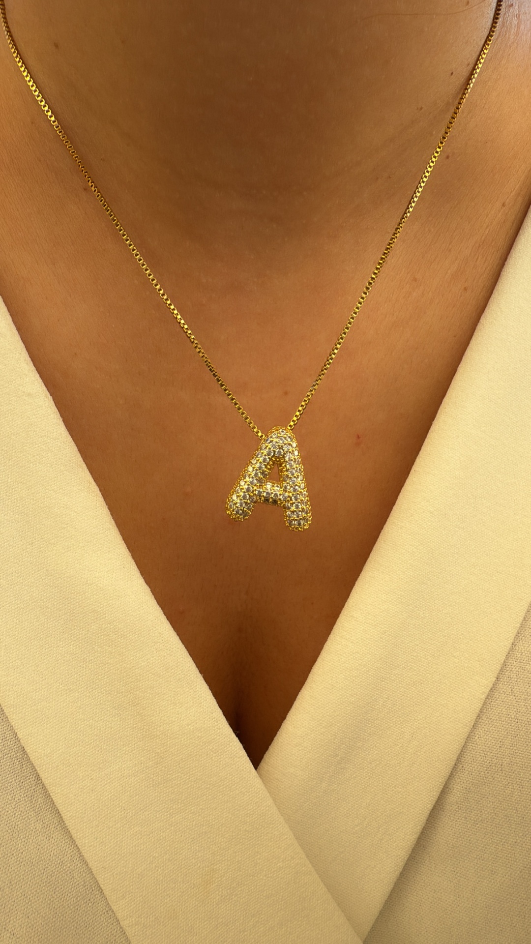 Colar dourado com pendente letra A cravejado de cristais