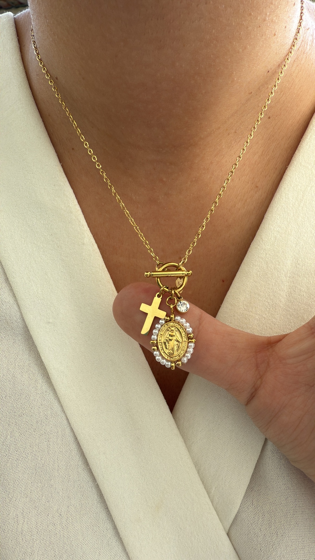 Colar dourado com pendentes de cruz, medalhão oval com cristais e pequeno cristal solitário