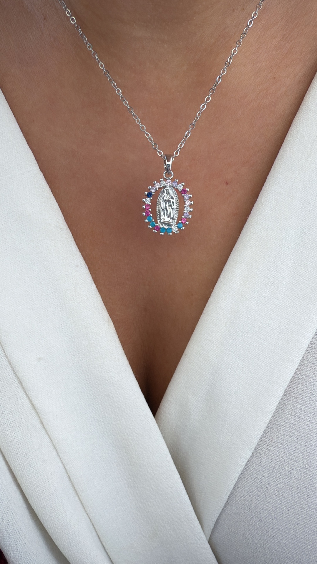 Colar prateado com pendente oval colorido em roupa branca
