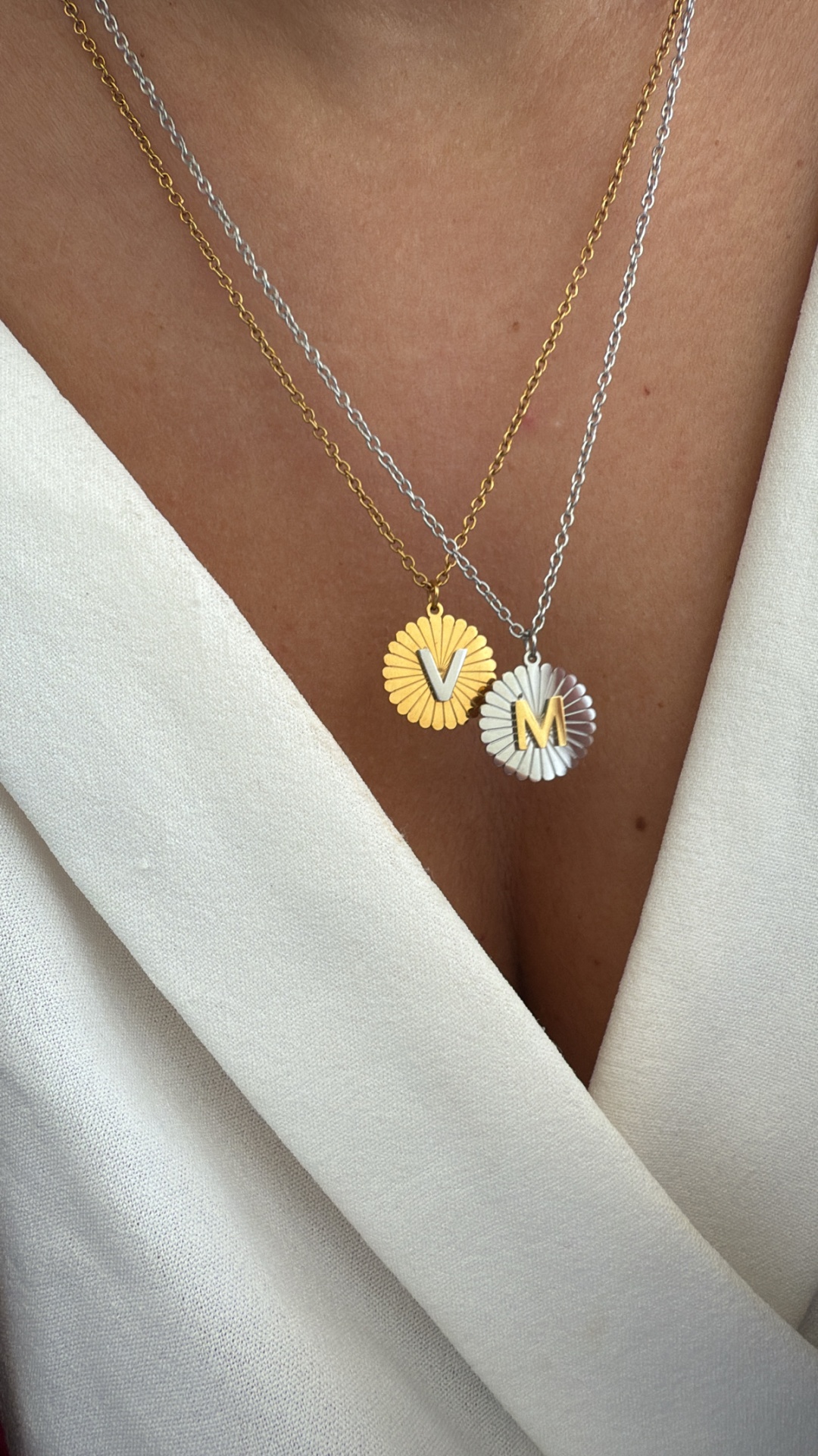 Colares dourado e prateado com pendentes redondos e letras V e M