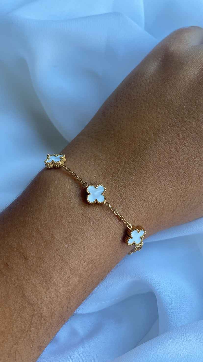 Pulseira dourada com pendentes em forma de trevo de quatro folhas