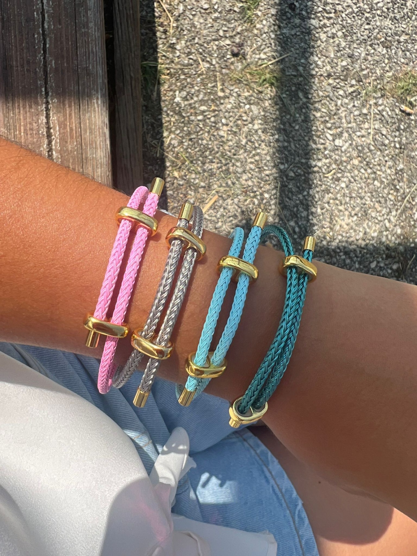 Pulseiras de corda coloridas com detalhes dourados no pulso