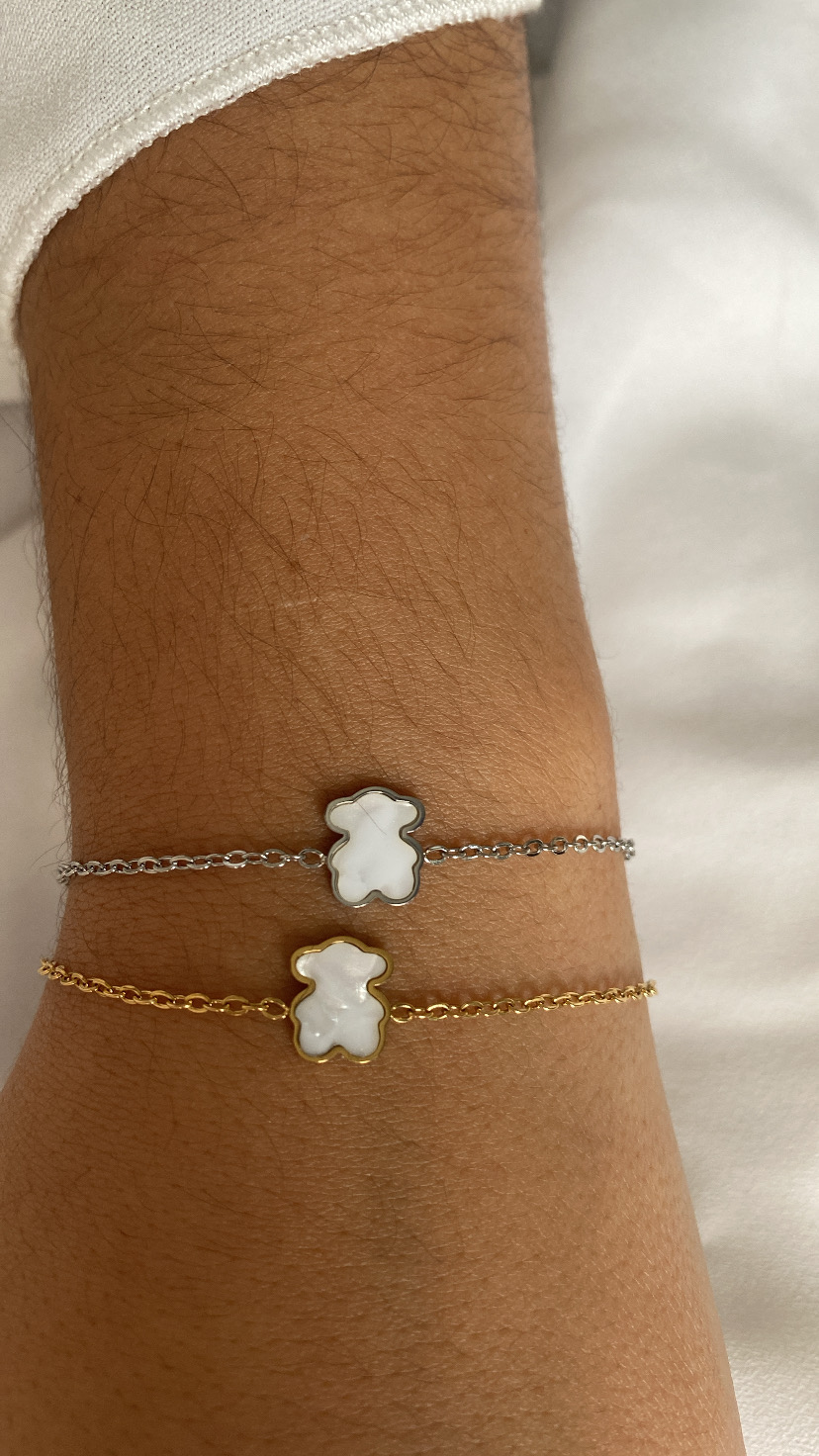 Pulseiras prateada e dourada com pendente de ursinho branco
