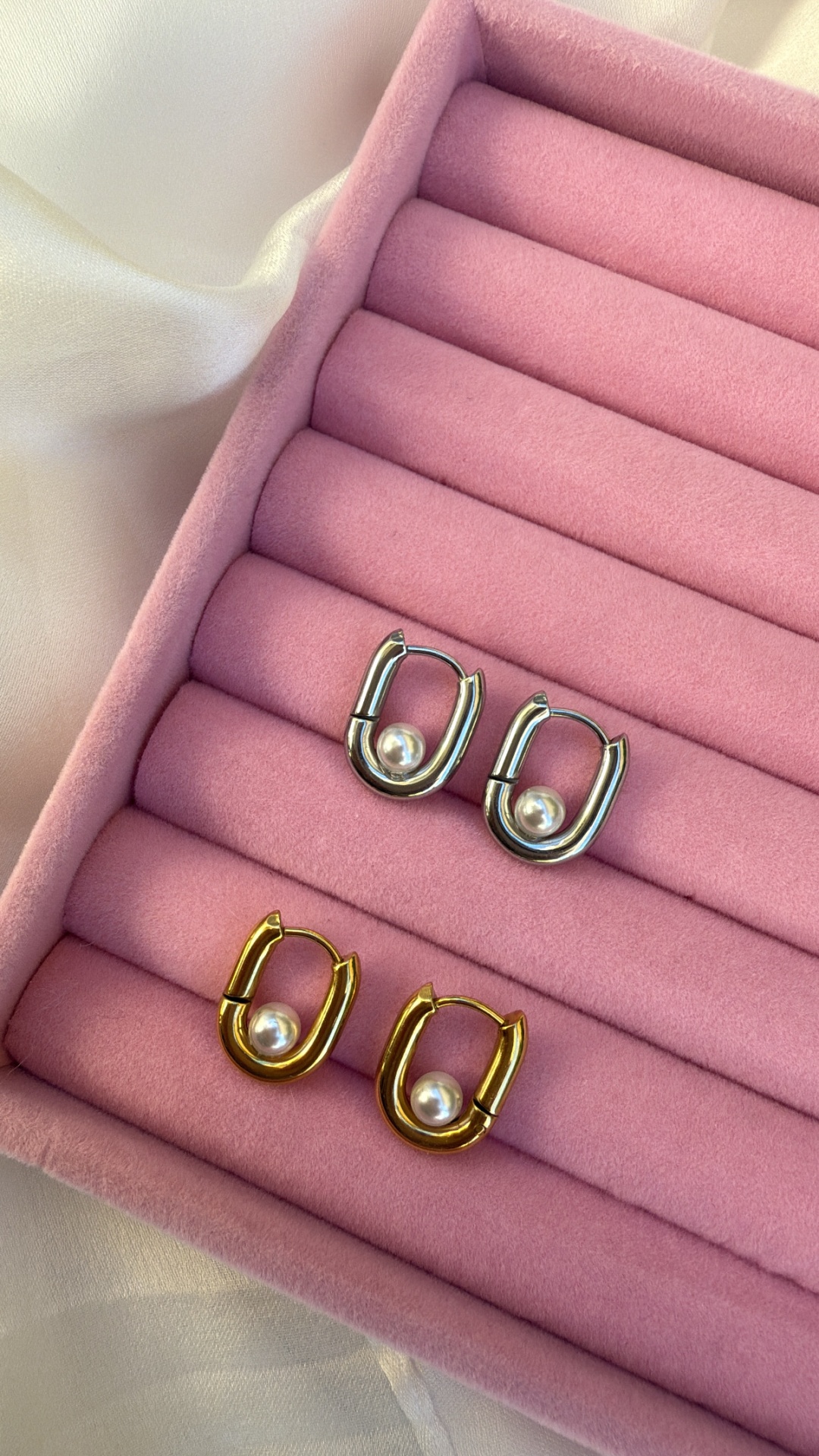 Duas pares de brincos ovais com pérola em caixa de veludo rosa
