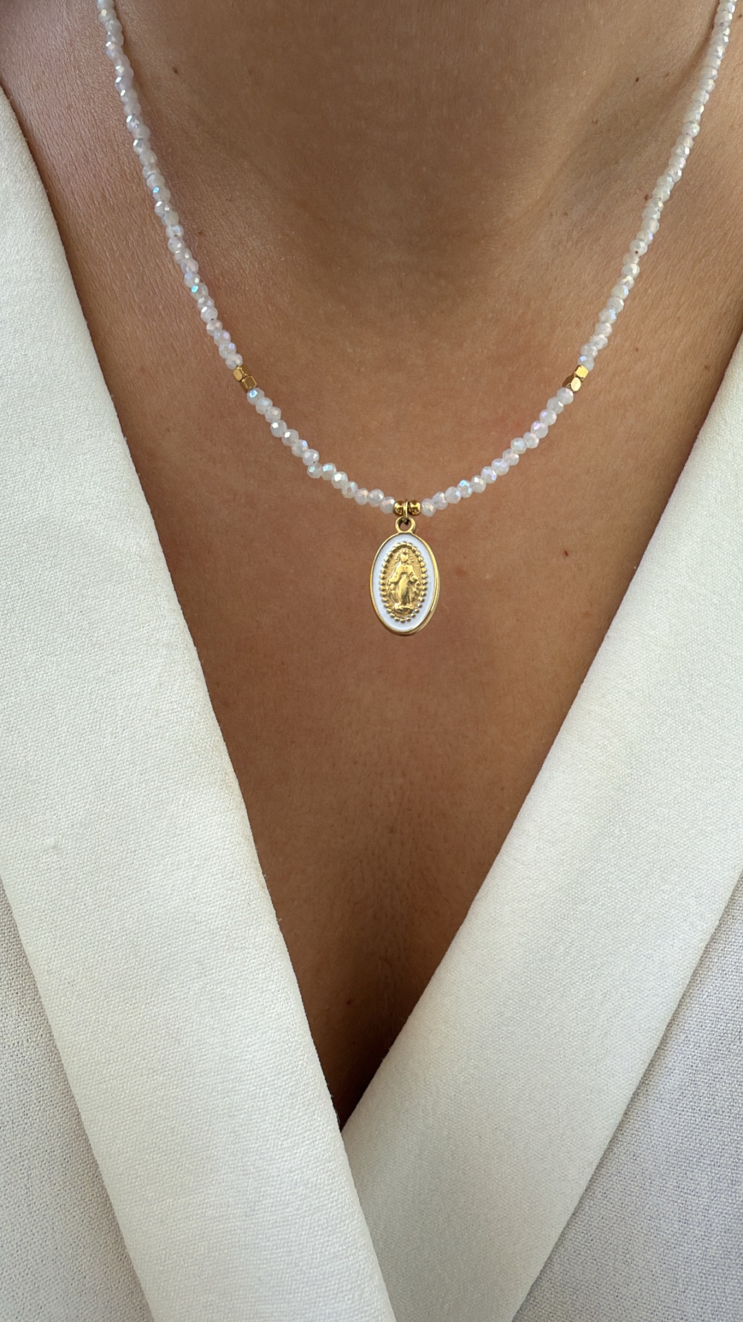 Colar com contas brancas, detalhes dourados e pendente oval religioso