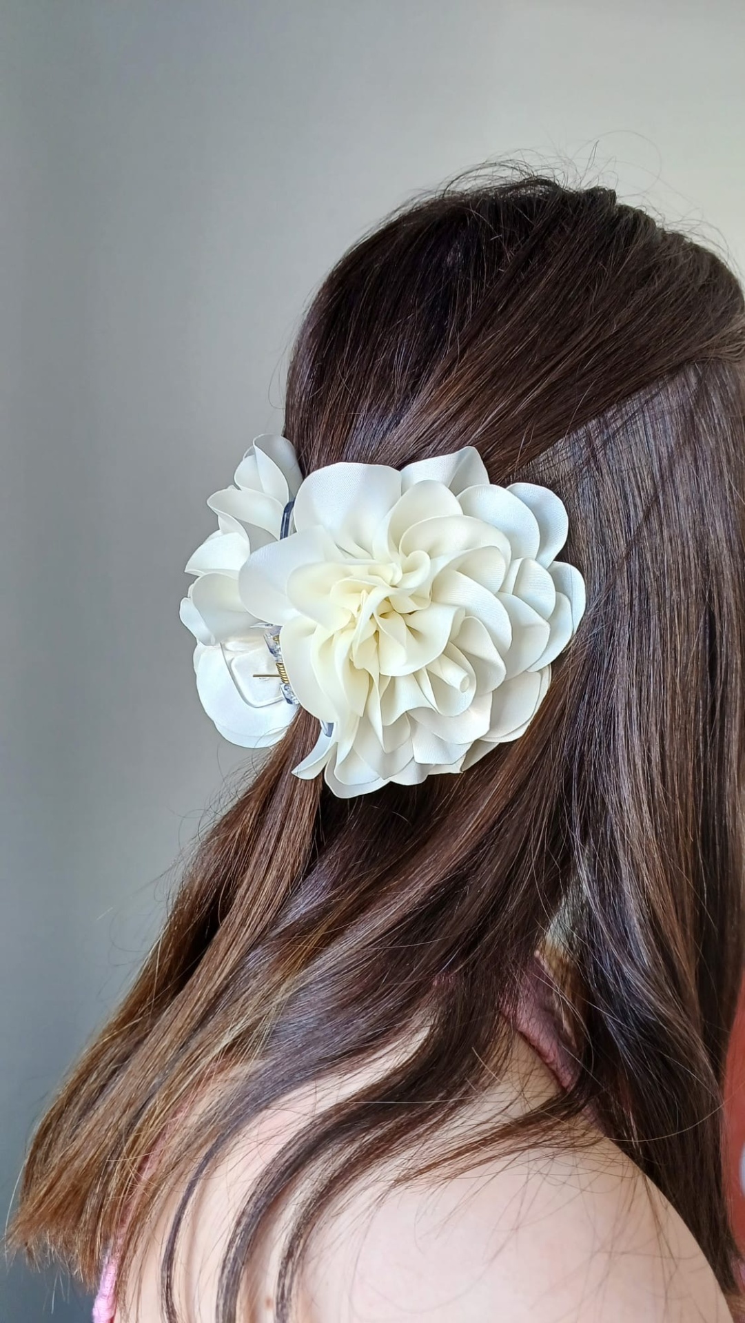 Presilha de cabelo com flor artificial branca em cabelo castanho escuro