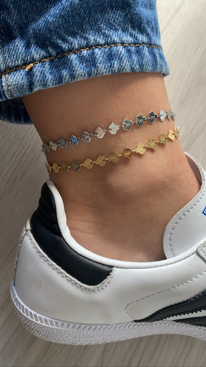 Tornozeleiras dourada e prateada em tornozelo com sapato branco e azul