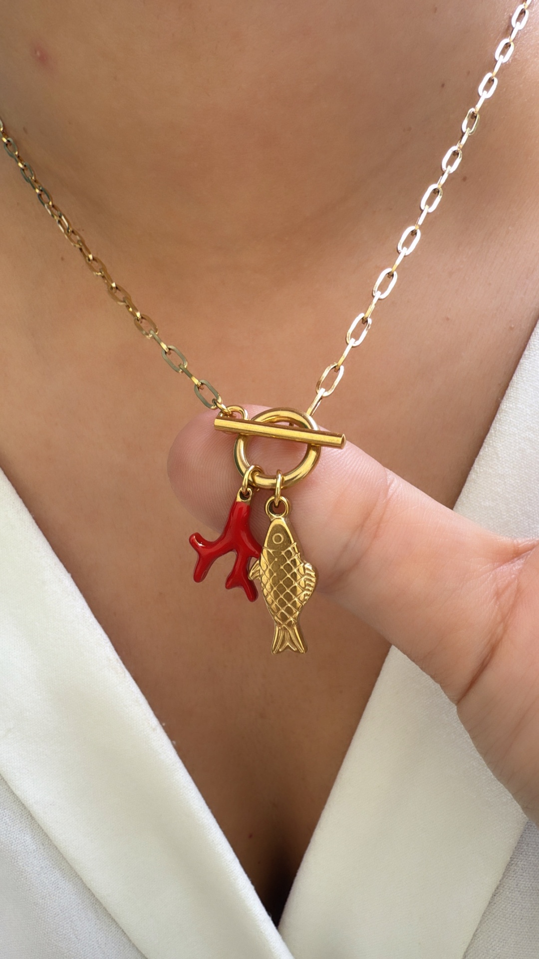 Colar dourado com pendente de peixe e coral vermelho