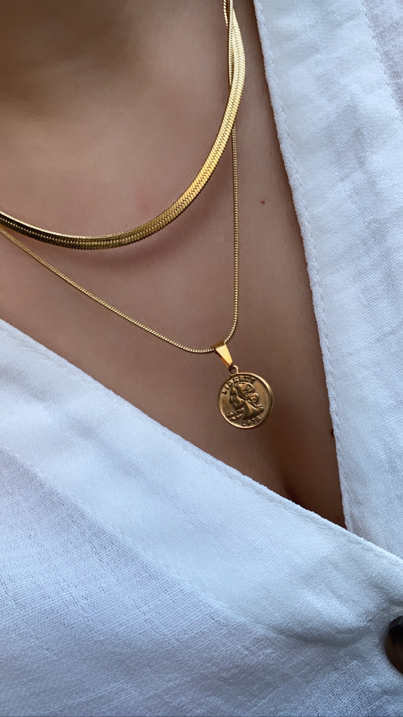 Colares dourados com pendente redondo e roupa branca