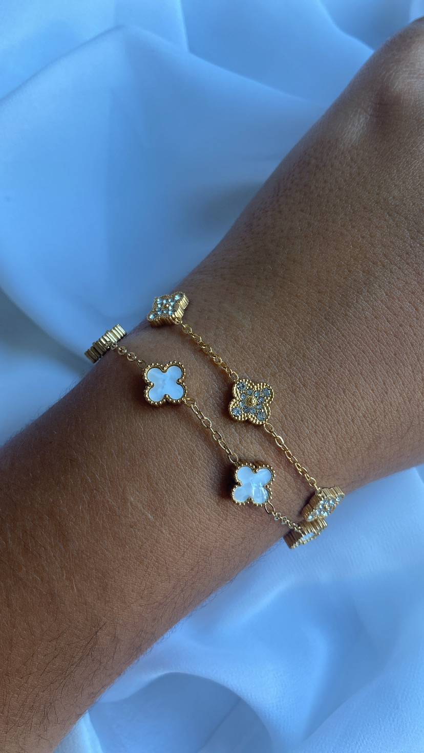 Pulseira dourada com flores em madrepérola no pulso