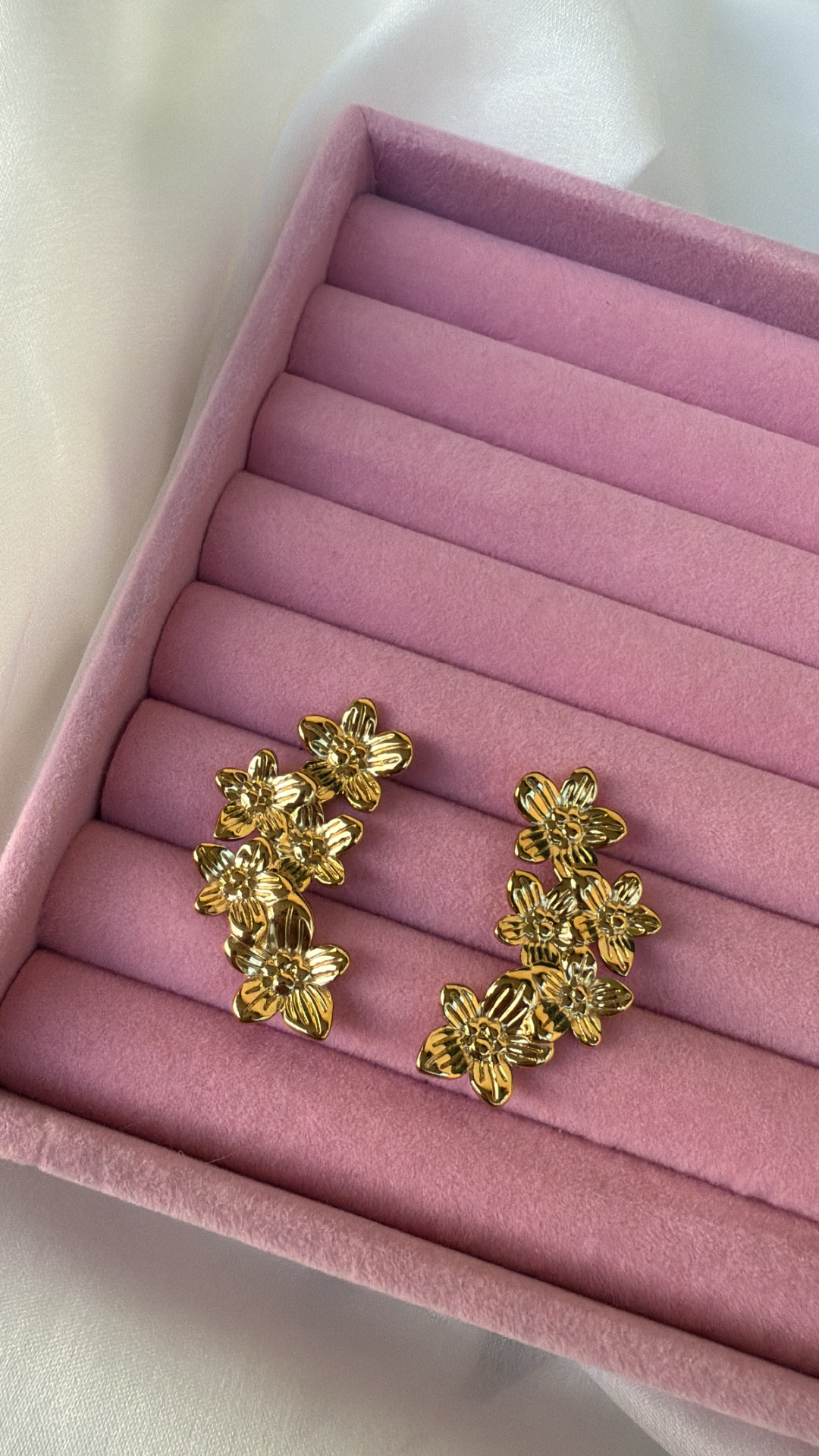 Brincos dourados com design de flores em caixa de veludo rosa