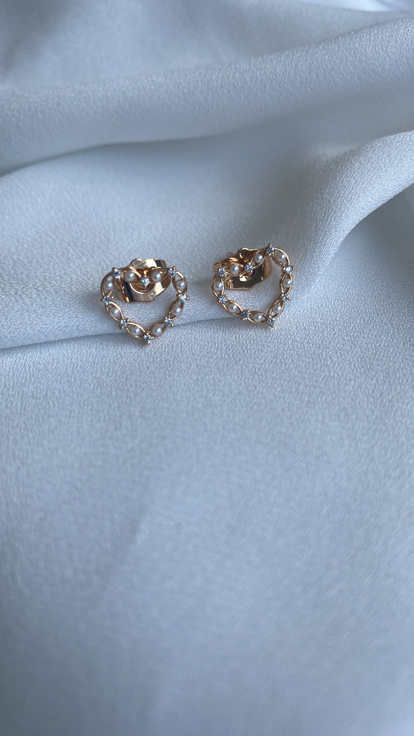 brincos coração dourados com cristais em tecido branco