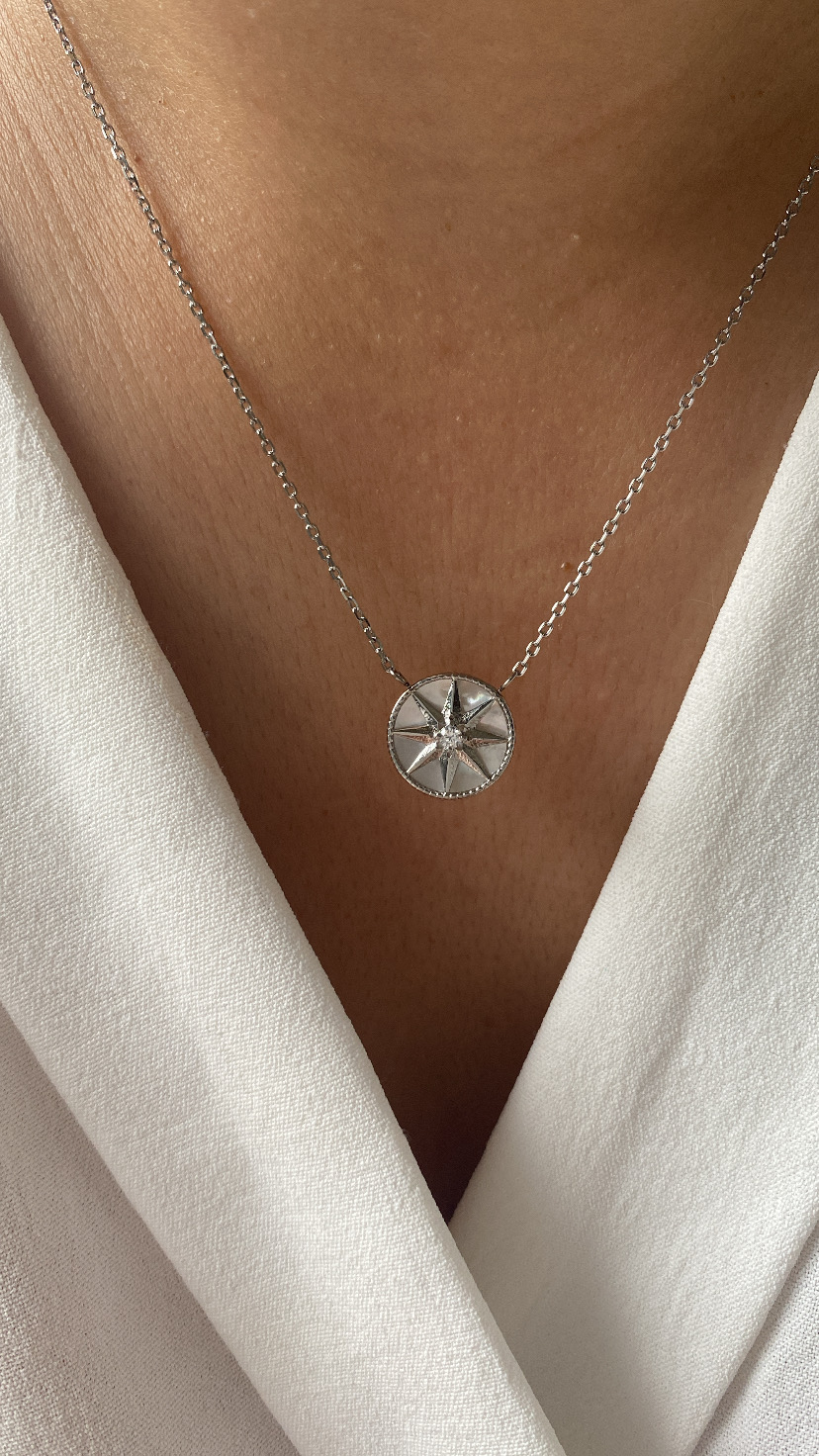 Colar prateado com pendente redondo e desenho de estrela com cristal no centro