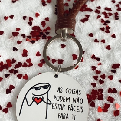 Porta-chaves com alça em couro castanho e pendente redondo com texto motivacional em português