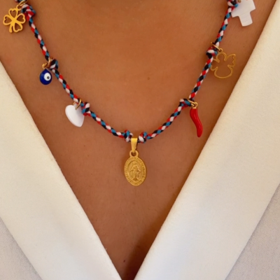 Colar colorido com diversos pendentes sobre roupa branca.