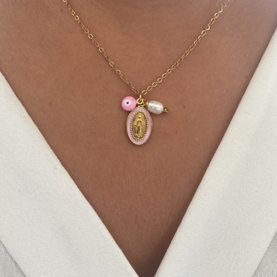 Colar dourado com medallhão rosa, conta rosa e pérola branca no decote branco