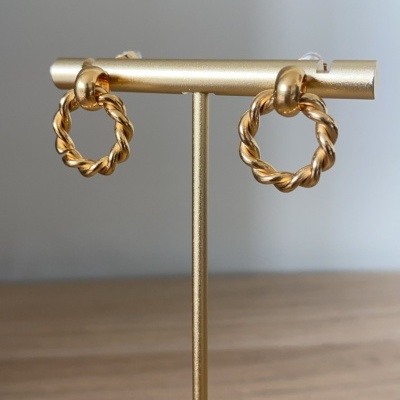 Brincos dourados em argola torcidada num suporte dourado