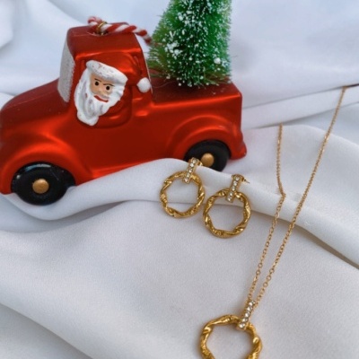 Miniatura de camião vermelho com Pai Natal, árvore de Natal verde e joias douradas sobre tecido branco