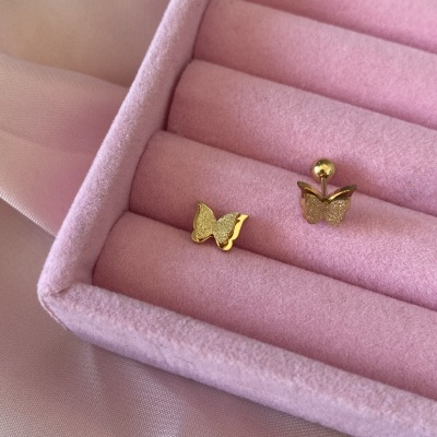 Par de brincos de borboleta em ouro numa caixa rosa almofadada