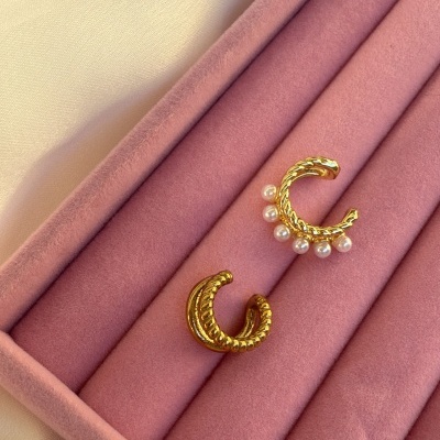 Brincos dourados em estojo rosa aveludado.