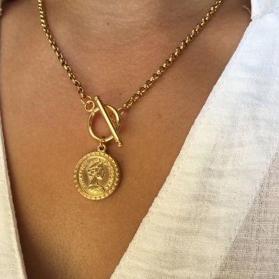 Colar dourado com pendente redondo e camisa branca