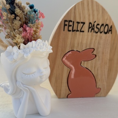 Vaso cerâmico com flores secas e placa de madeira decorativa de Páscoa.