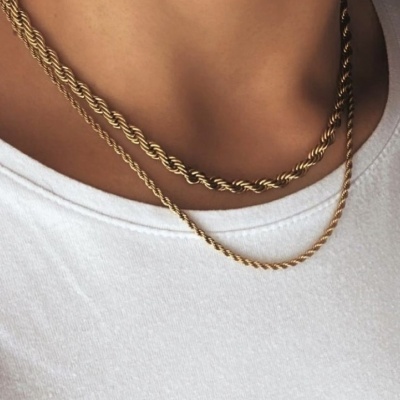 Duas correntes douradas torcidas usadas no pescoço com t-shirt branca