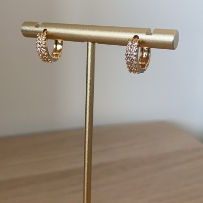 Brincos dourados com cristais num suporte dourado