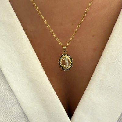 Colar dourado com pendente oval decorado e roupa branca
