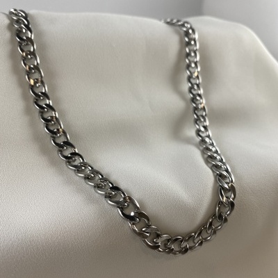 Colar prateado de corrente com elos grossos sobre superfície branca