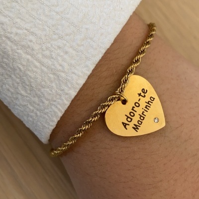 Pulseira dourada com pendente em forma de coração e gravação