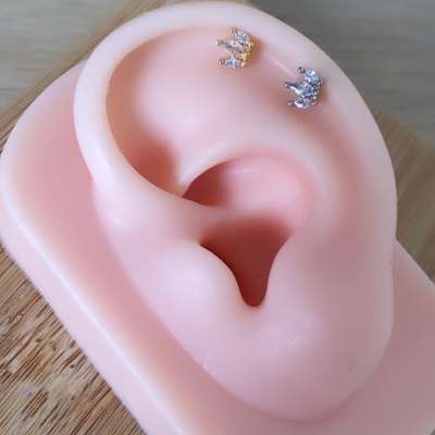 Brincos de coroa em molde silicone orelha cor de pele sobre madeira