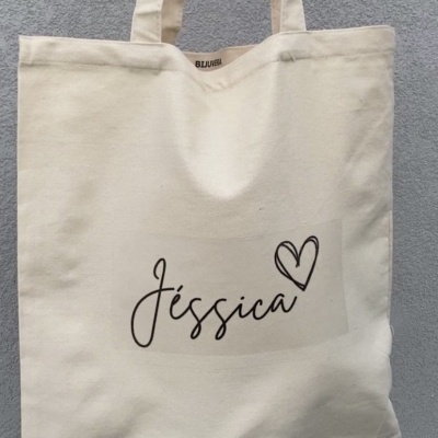 Saco de tecido bege com o nome Jéssica e um coração desenhado