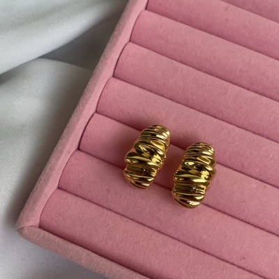 Brincos dourados ondulados em estojo de veludo rosa