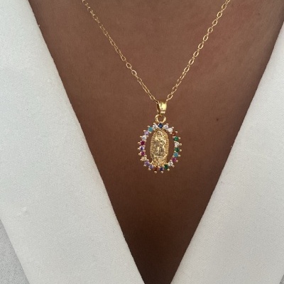 Colar dourado com pendente oval colorido num pescoço