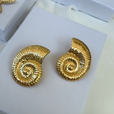 Brincos dourados em formas de concha e estrela-do-mar em caixas brancas